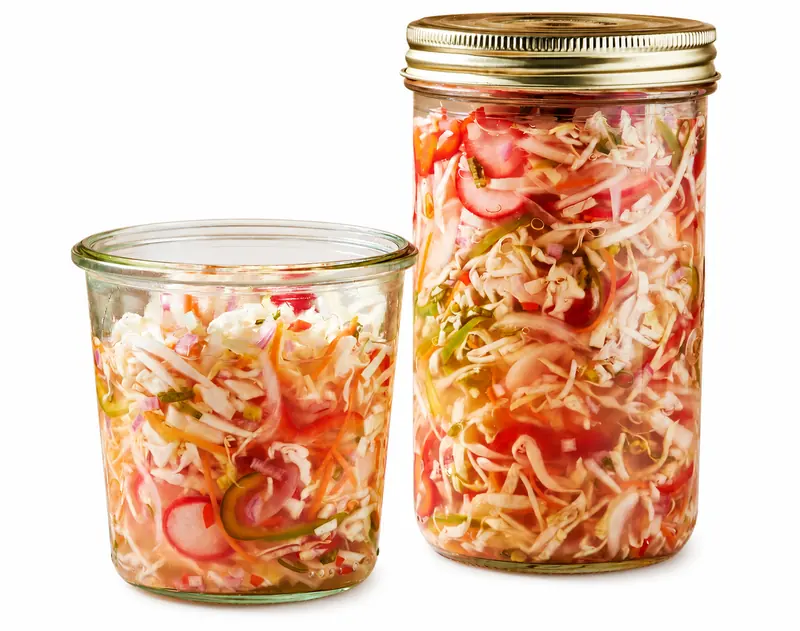 Jars of Haitian pikliz — spicy pickled cabbage, carrots and peppers